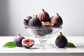 Glass vase with fresh ripe figs and halves on a white table. Ripe summer fruits Royalty Free Stock Photo