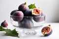 Fresh juicy figs and halves lie in a glass vase and nearby on a white table. Ripe summer fruits Royalty Free Stock Photo