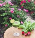 Glass of vegetable juice on the table. A bunch of radishes