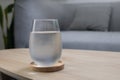 The glass of very cold water on the wooden table at living room