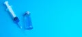 Glass vials and a medical syringe with a coronavirus vaccine on a blue background Royalty Free Stock Photo