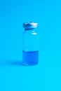 Glass vials and a medical syringe with a coronavirus vaccine on a blue background Royalty Free Stock Photo