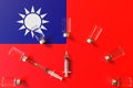 Syringes and medical vials on the flag of Taiwan. Vaccination related conceptual 3D rendering