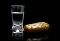 Glass of vodka with pickled cucumber isolated on black background