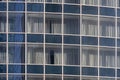 Glass wall of modern building with other buildings reflection. Windows are closed with curtains Royalty Free Stock Photo