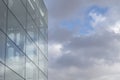 Glass wall of modern office building against cloudy sky. Copy space for text Royalty Free Stock Photo