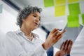 Glass wall, tablet and business woman planning, strategy and research in workplace. Sticky notes, brainstorming and Royalty Free Stock Photo