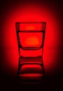 Glass of water, alcohol, vodka, juice or another drink on a rich dark red gradient background Royalty Free Stock Photo