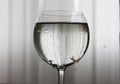 A glass of water on a background of vertical lines. Royalty Free Stock Photo