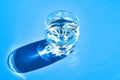 Glass of water on blue background with hard light and shadows, Reflections on water. Alcohol drinks. Thirsty Royalty Free Stock Photo