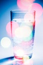 A glass of water with colorful bokeh glowing. Water - the source of life on the Earth concept Royalty Free Stock Photo