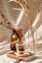 Glass of water, decorative dried flowers in vases