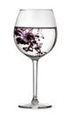 Glass with water and drop of violet ink. Half full glass for wine isolated on white background with clipping path Royalty Free Stock Photo