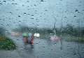 Glass water droplets. Blurred background. Road with cars. Concept. Rainy season driving on bad weather days. poor visibility feels Royalty Free Stock Photo