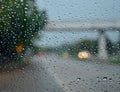 Glass water droplets. Blurred background. Road with cars. Concept. Rainy season driving on bad weather days. poor visibility feels Royalty Free Stock Photo