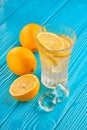 Glass of water with fresh lemon juice and ice cubes on the blue wooden table Royalty Free Stock Photo