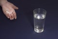 Glass of water with a hand pill on a blue background antibiotic