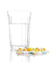 Glass with water and a heap of tablets, pills