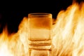 glass of water with ice against the background of fire