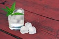 Glass of water with ice cubes and mint on wooden table Royalty Free Stock Photo