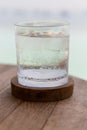 Glass of water with ice cubes on table at beach Royalty Free Stock Photo