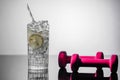 A glass of water, lime and lemon and dumbbells. Detoxification concept Royalty Free Stock Photo