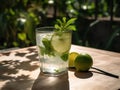 a glass of water with lime and mint on a wooden table with a spoon and a lemon on the side of the glass and a green leaf on the Royalty Free Stock Photo