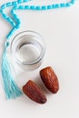 Glass of water, Organic dates Medjool and rosary. Concept breaking fast.