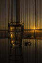 Glass of water an a pill of fish oil at table in sunrise Royalty Free Stock Photo