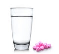 Glass of water and pills on white background Royalty Free Stock Photo