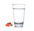 Glass of water and pills on white background Royalty Free Stock Photo