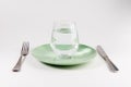 Glass of water in a plate with knife and fork isolated on white Royalty Free Stock Photo