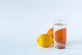 Glass of water with ripe lemon and orange on white table. Royalty Free Stock Photo