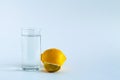 Glass of water with ripe lemon and slice on white table. Royalty Free Stock Photo