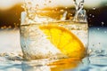 Glass of water with slice of lemon and splash against blurred landscape background Royalty Free Stock Photo