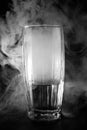 Glass with water and smoke on a dark background, abstrakt background