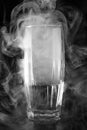 Glass with water and smoke on a dark background, abstrakt background