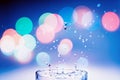 A glass of water with a splash and colorful bokeh glowing. Water - the source of life on the Earth concept Royalty Free Stock Photo