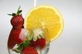 a glass of water with strawberries and an orange slice Royalty Free Stock Photo