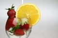 a glass of water with strawberries and an orange slice Royalty Free Stock Photo