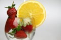 a glass of water with strawberries and an orange slice Royalty Free Stock Photo