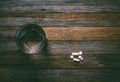 Glass of water tablets and capsules on wooden table, top view