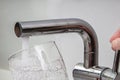 Glass at water tap and filling water with lead contamination Royalty Free Stock Photo