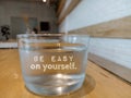 Glass of water with text - Be easy on yourself. Self love and care concept. Healthy lifestyle with glass of mineral water/ Royalty Free Stock Photo