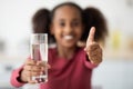 Glass of water and thumb up, unrecognizable girl drinking water Royalty Free Stock Photo