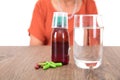 A glass of water and various medicines in front of the old Chinese lady