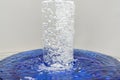 A glass of water, water with bubbles overflows through glass