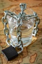 A glass of water wrapped in a chain and closed with a padlock. The concept of the problem of small drinking water resources in the