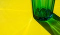 Glass with water on yellow background. selective focus. concept of light refraction