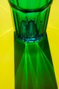 Glass with water on yellow background. selective focus. concept of light refraction